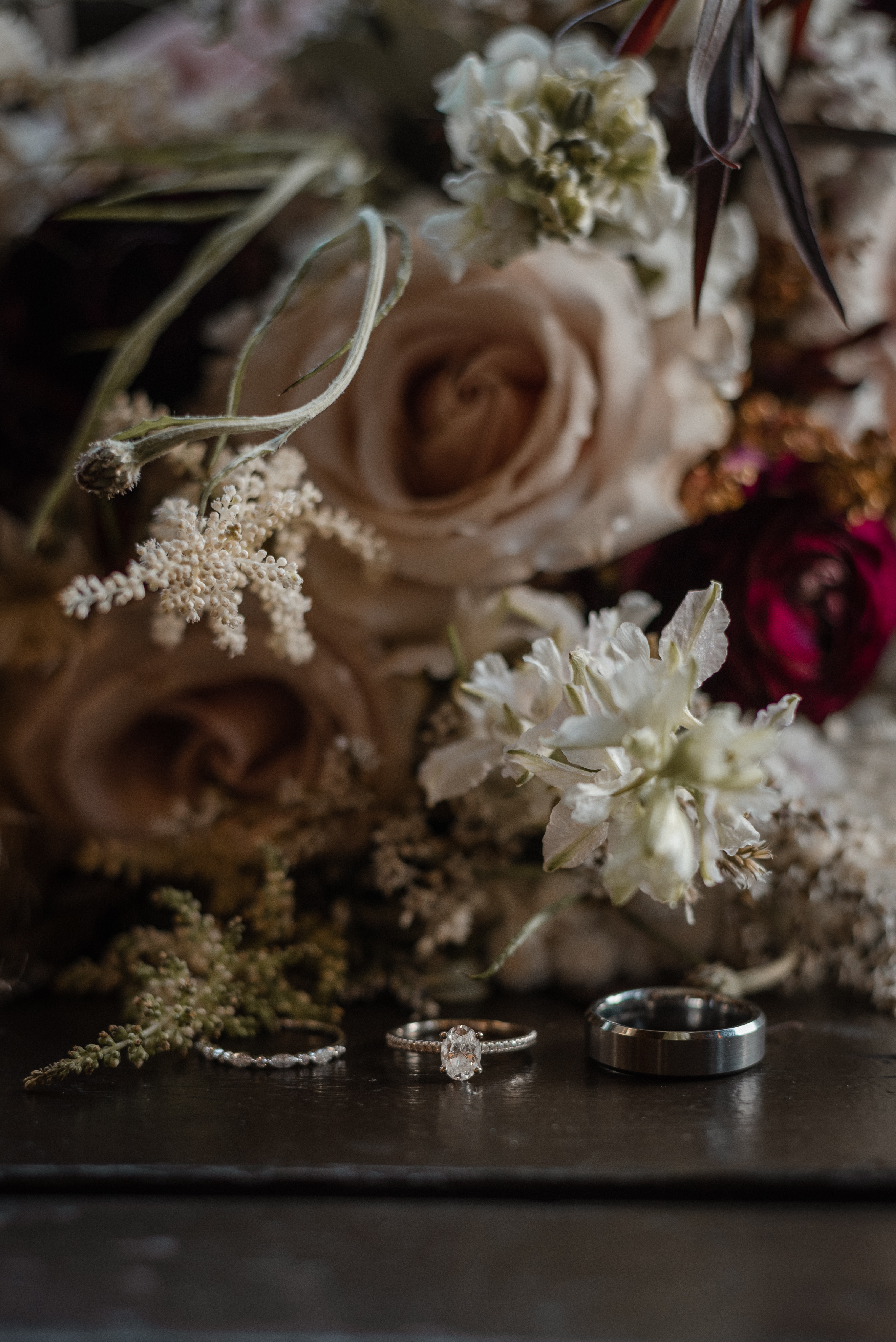 Wedding Bands laid next to florals on a reflective surface on Vancouver Island