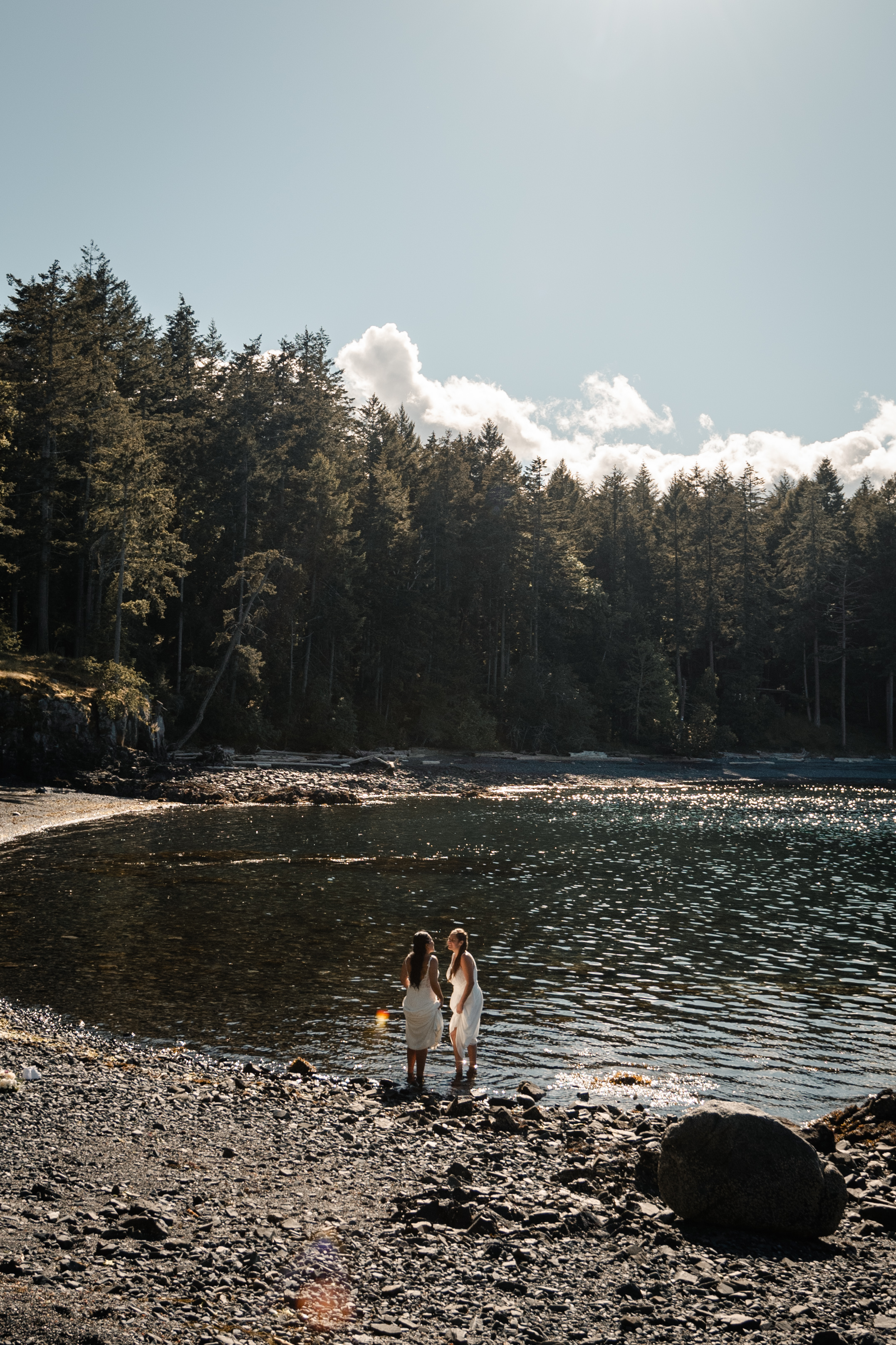 Same sex couple dipping their toes into the ocean in Nanoose, on Vancouver Island