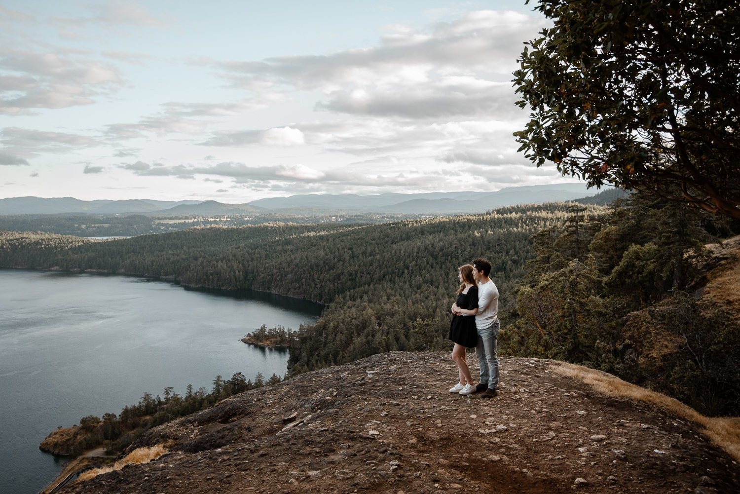 A couple holds each other close looking out at the beautiful views from Stoney Hill Regional Park on Vancouver Island