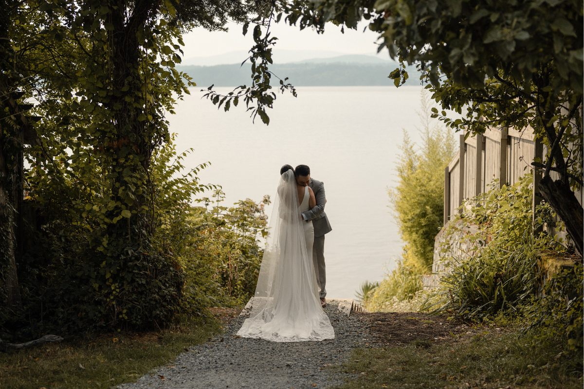 A bride and groom embrace during their first look at Deep Cove Winery on Vancouver Island