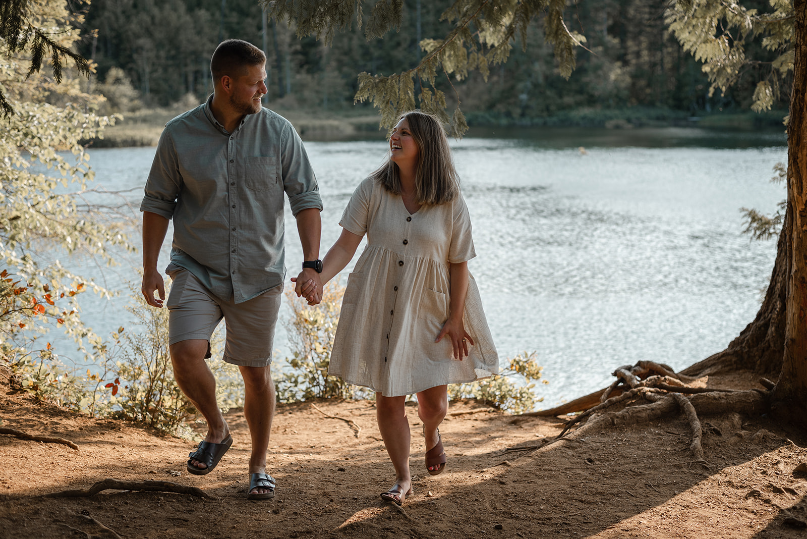 A candid moment of a couple walking in the Bevan Trails near the water.